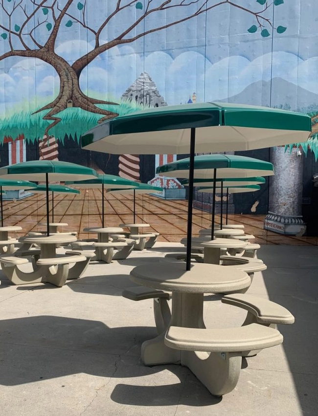 Fiberglass hard-top patio umbrella shading an outdoor food court table